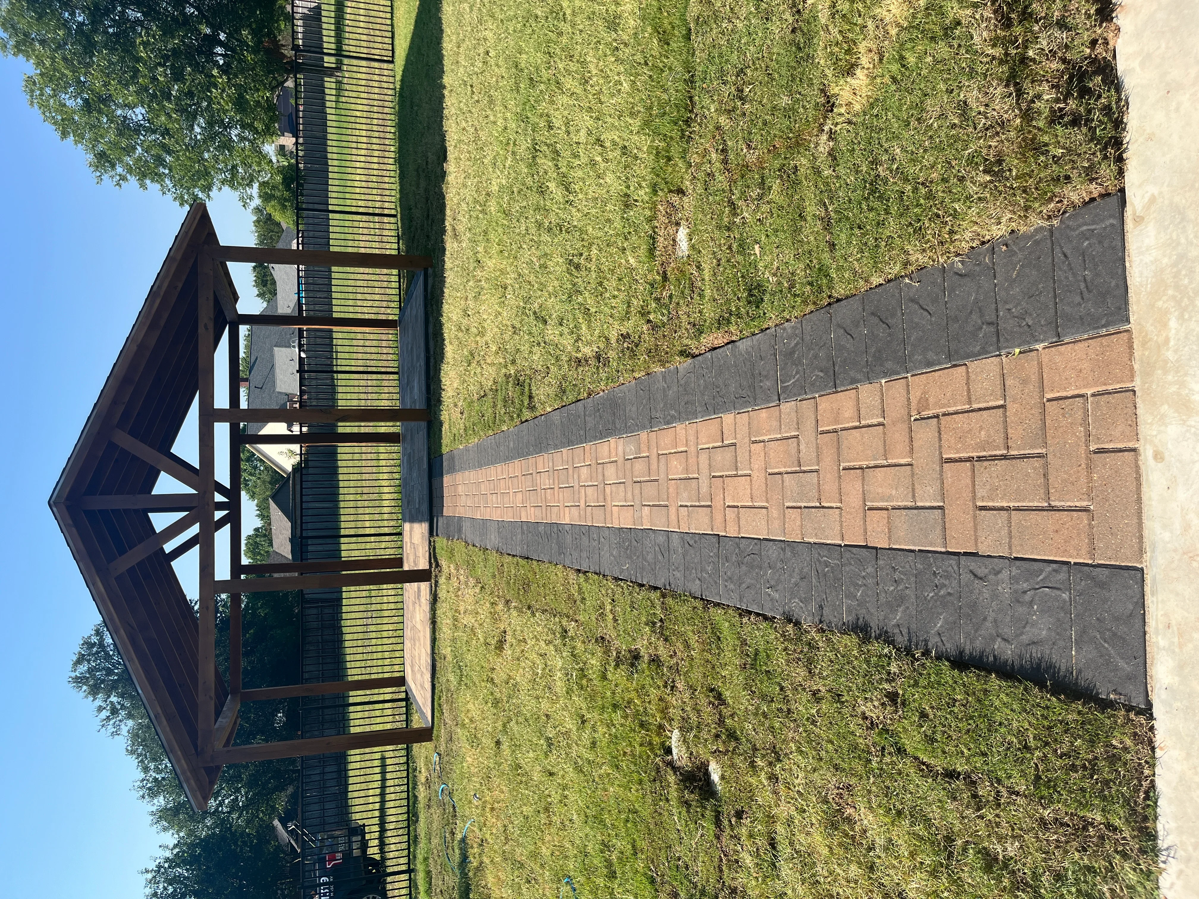 Clay brick paver driveway with gray permeable edge pavers and landscape fabric edging