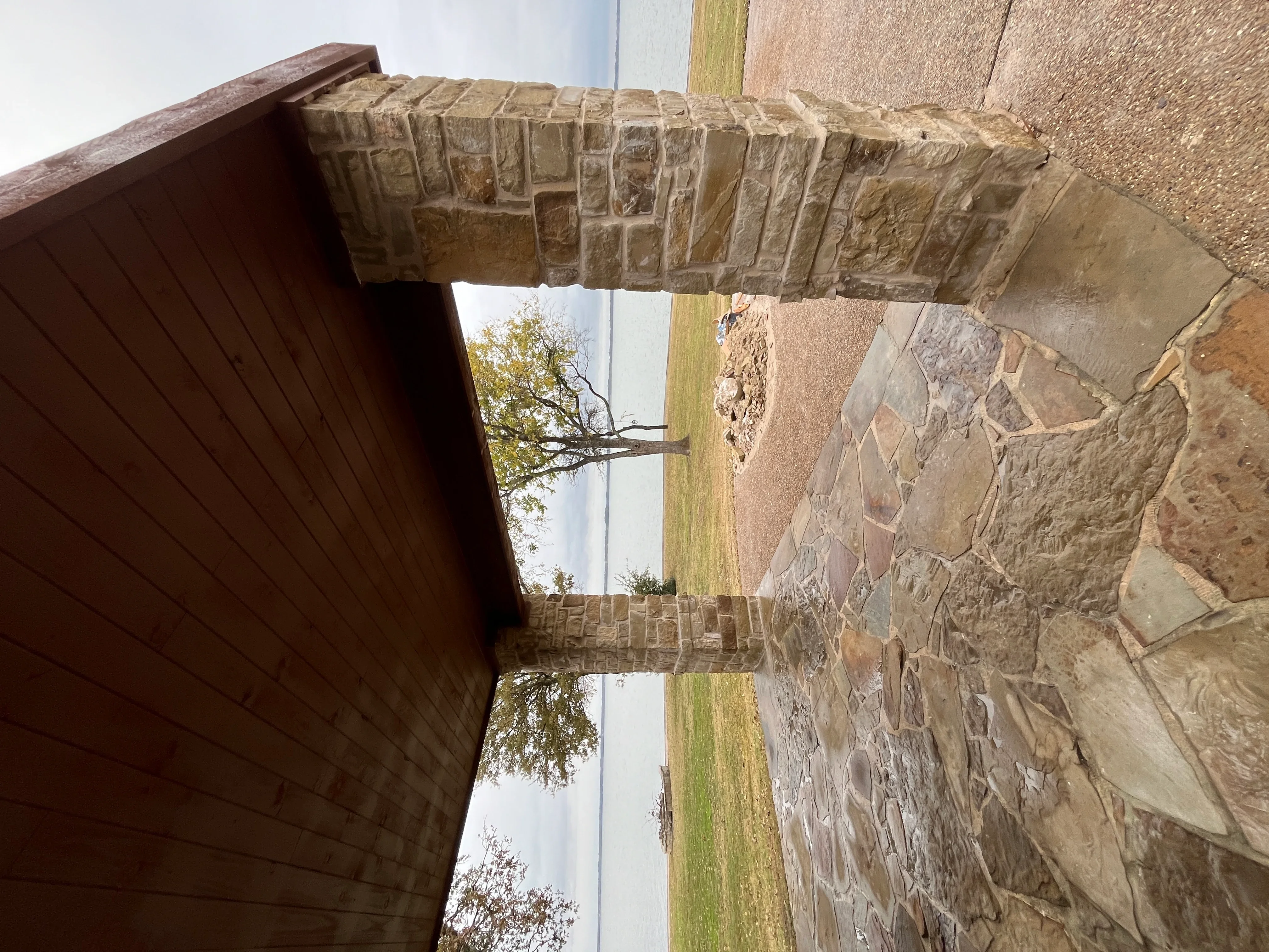 Stacked stone veneer chimney with earth-tone masonry and mortar joints